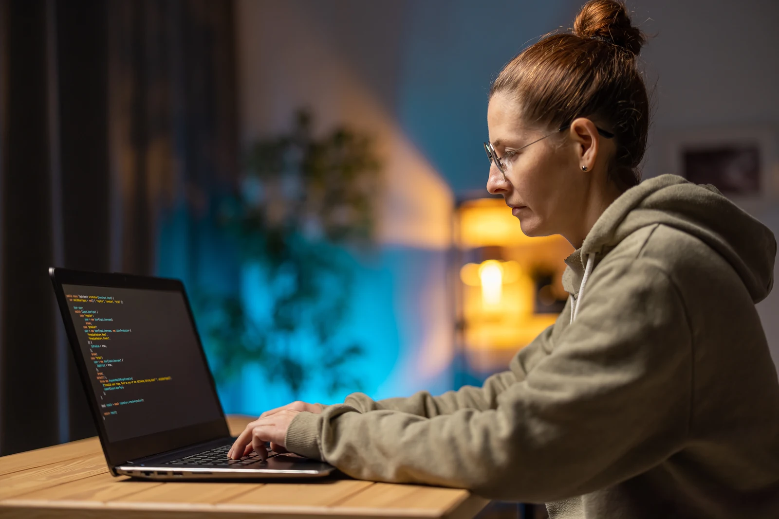 Software developer writing code on a laptop while working remotely