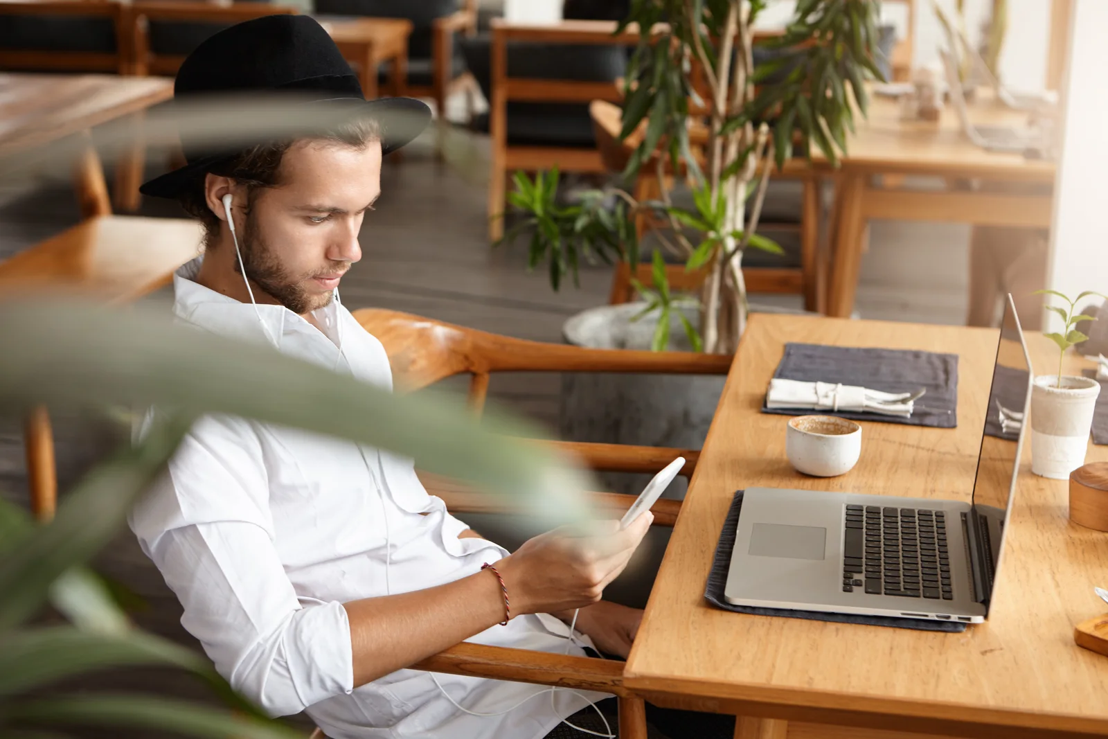 What is hybrid work in practice: a young professional working on a laptop and phone away from the office